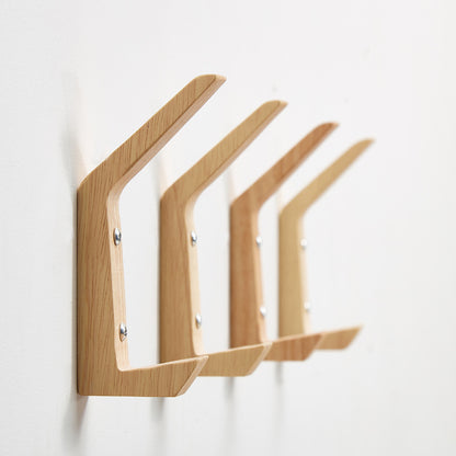 Minimalist wooden wall hooks for coats and bags.