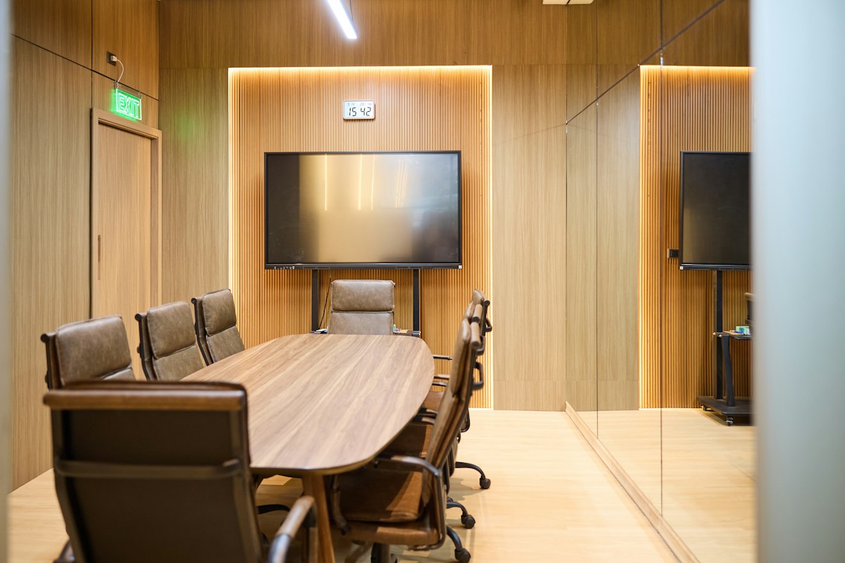 Conference room with an oval timber table and upholstered chairs