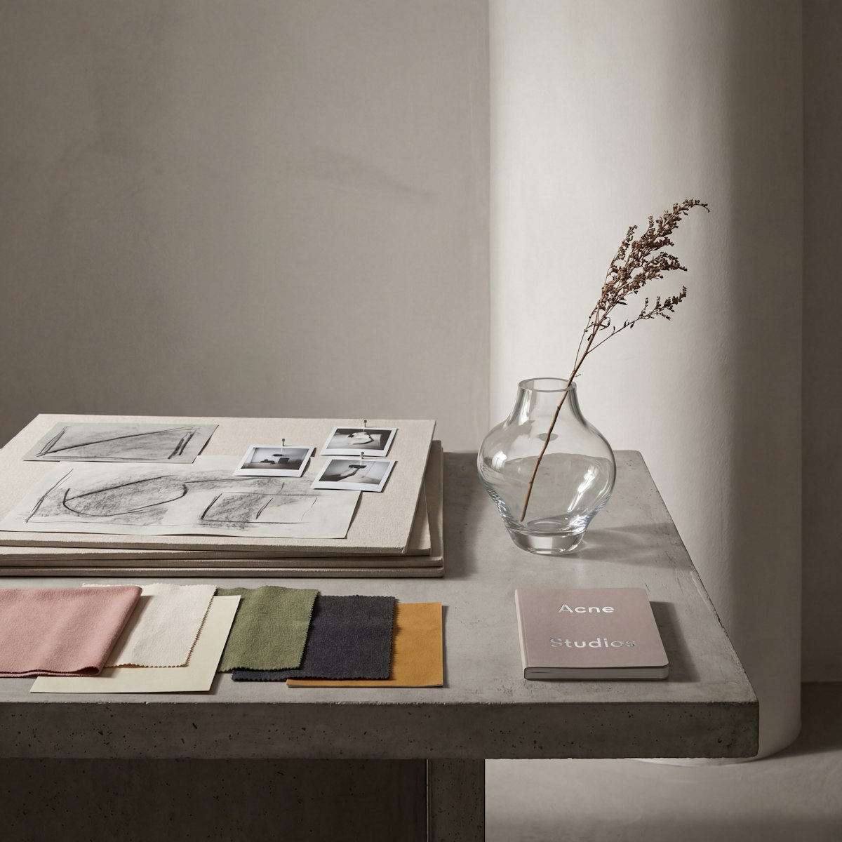 Fabric swatches, sketches and a small vase laid out as a mood board