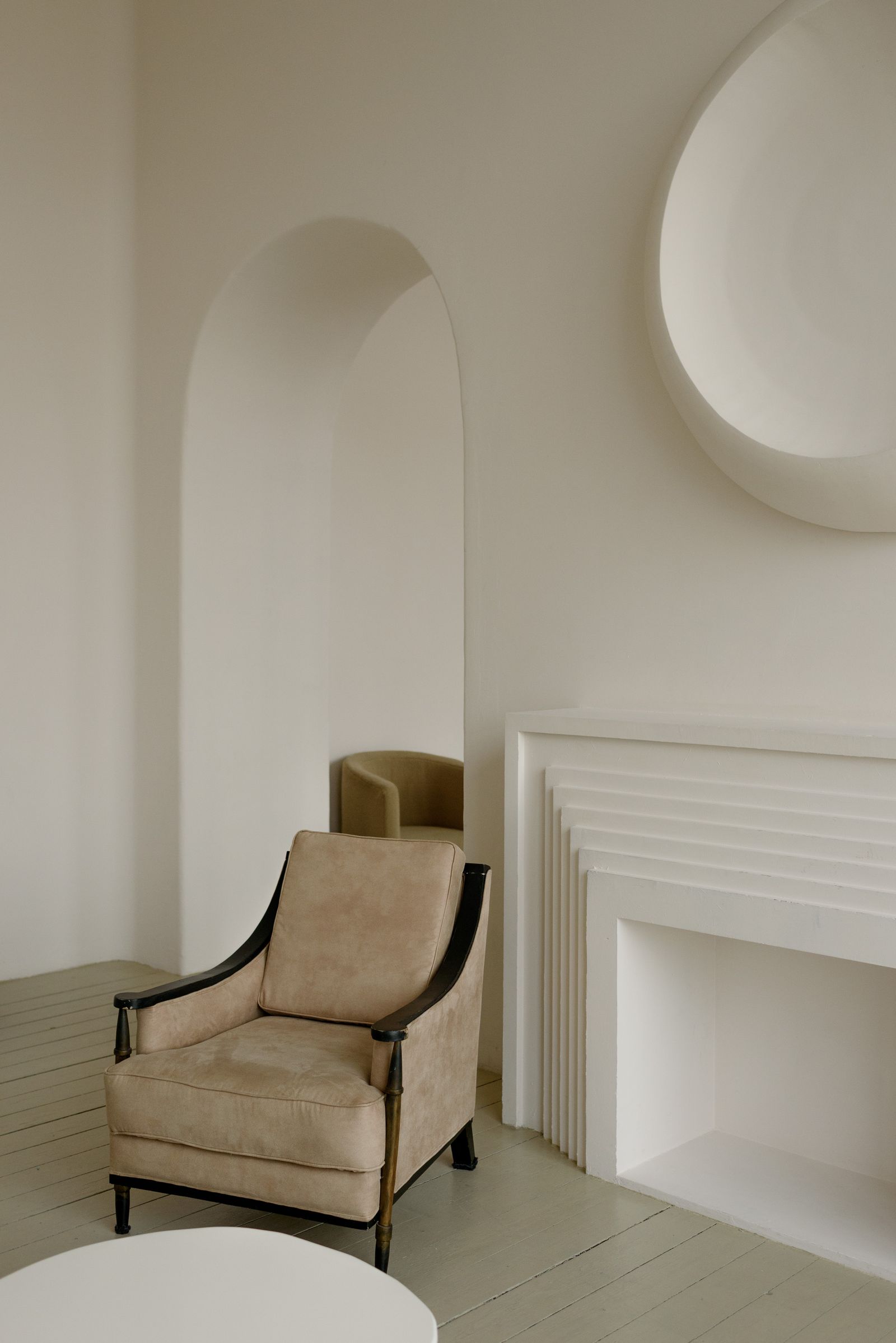 Minimalist white room with soft curtains and a single armchair