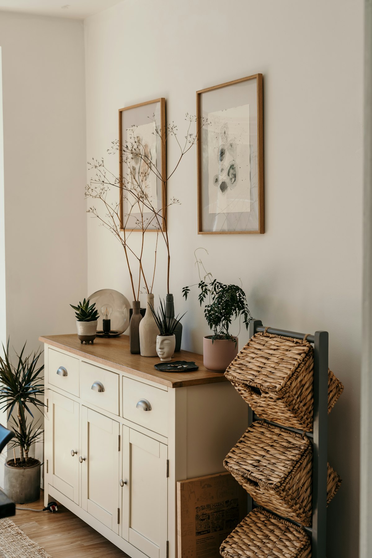 Wooden sideboard styled with plants, vases and woven baskets