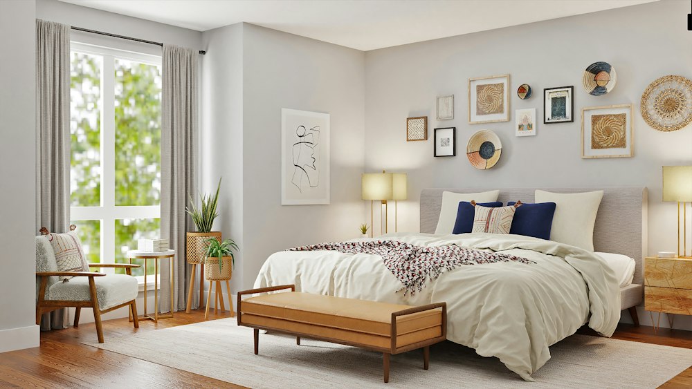 Sunlit bedroom with a low timber bed, leather bench and framed wall art
