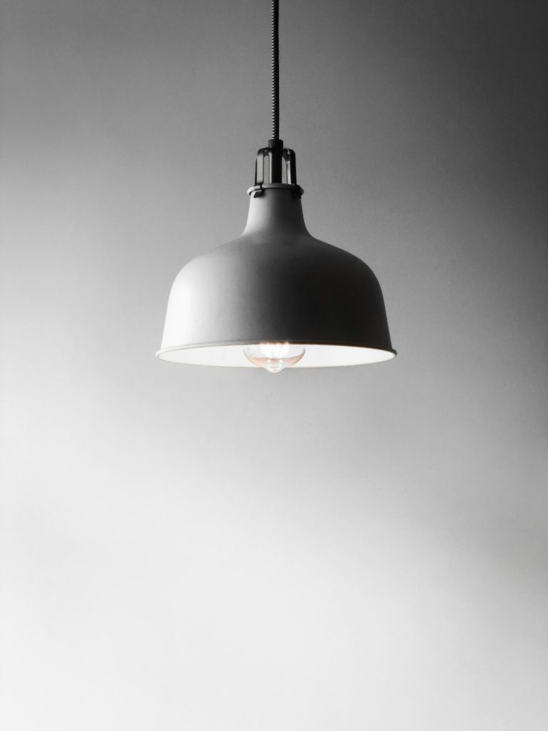 White pendant lamp hanging against a pale wall